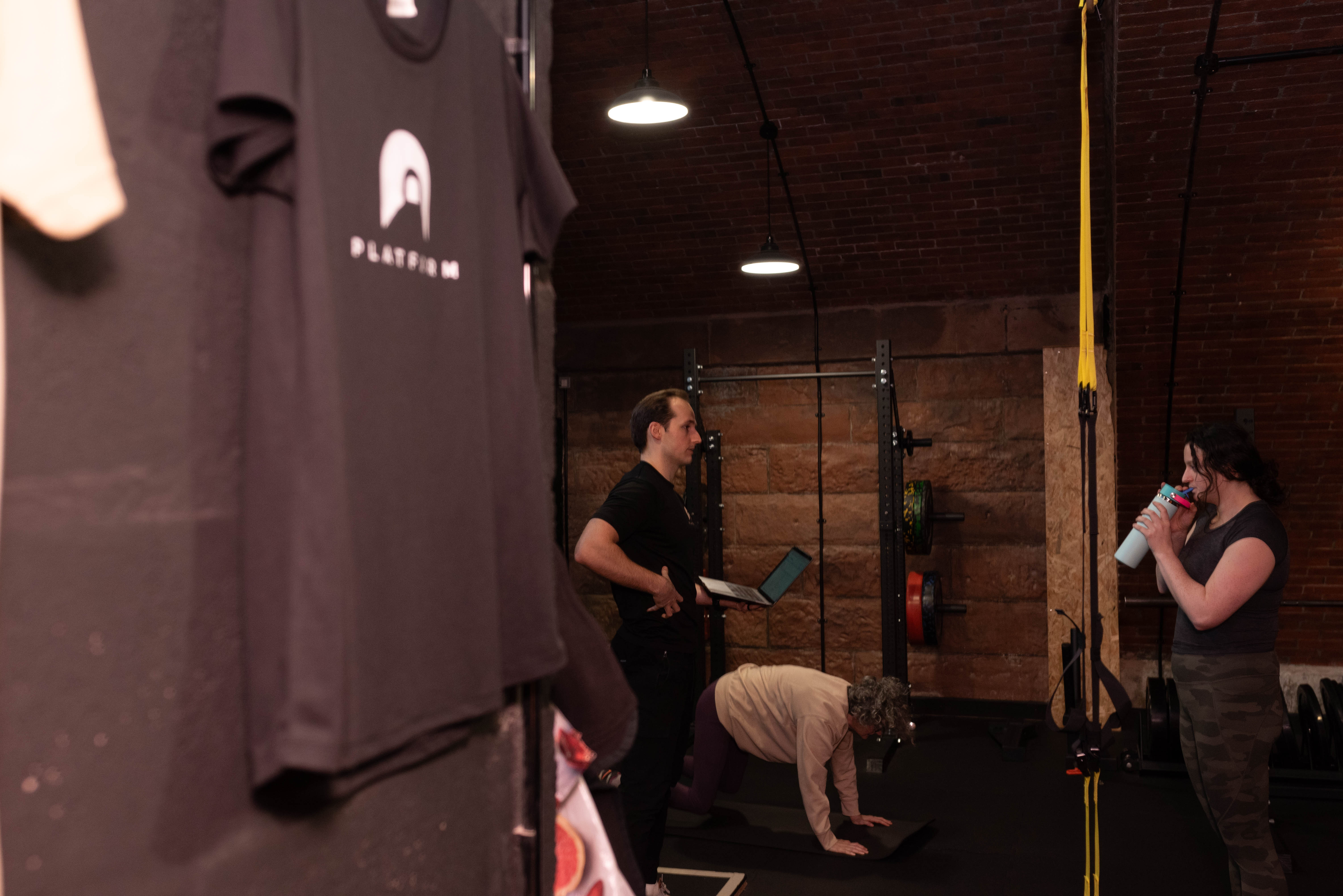 Jamie Henderson reviewing a client programme on a laptop at Platform Health and Fitness, illustrating the business side behind personal trainer course cost Edinburgh decisions